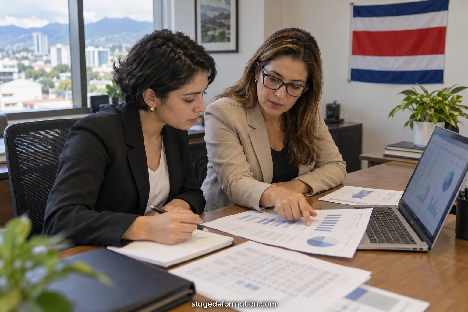 Étudiants analysant des tableaux financiers sur ordinateur dans une salle de réunion d’un établissement bancaire